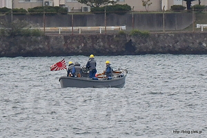 港内に浮かぶ内火艇 - 出港するイージス艦「きりしま」